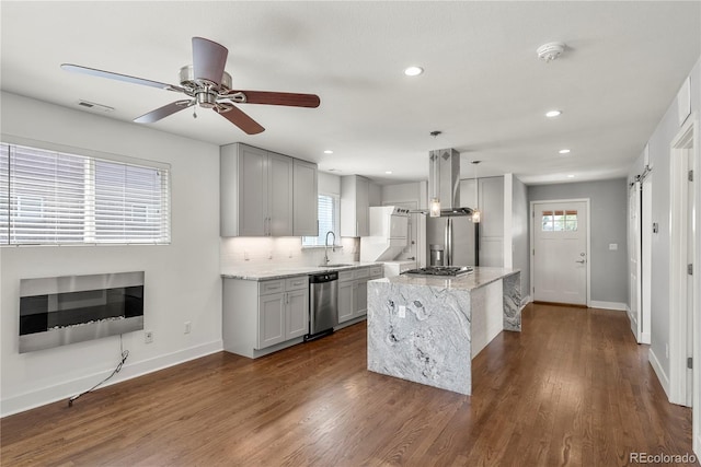 kitchen with stainless steel appliances, a sink, baseboards, light stone counters, and recessed lighting