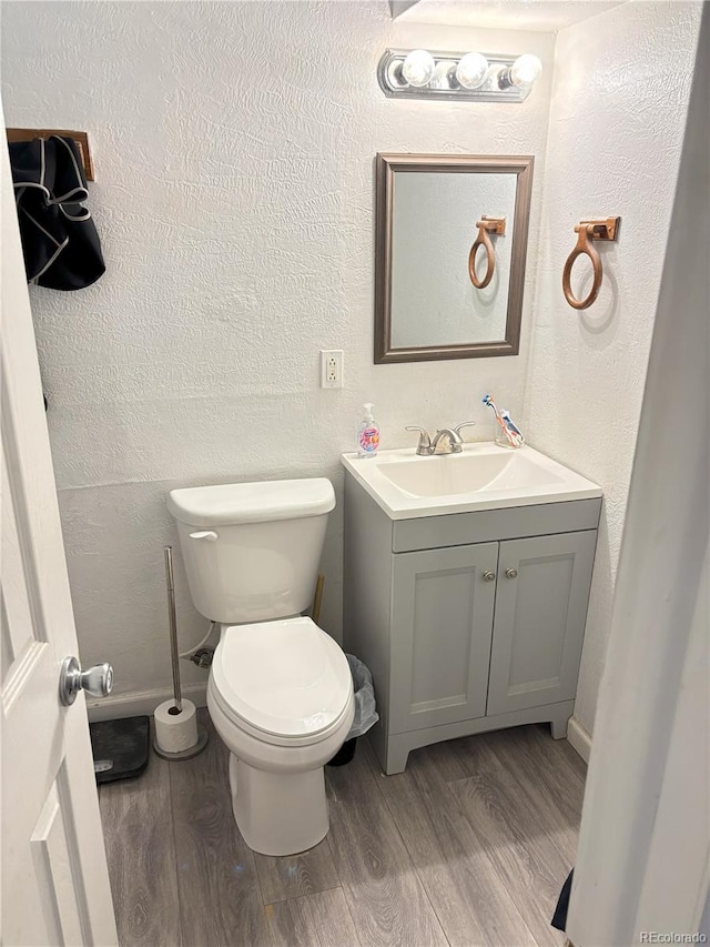 428 Prospect Ave, La Junta, CO 81050 - half bath featuring a textured wall, wood finished floors, and vanity