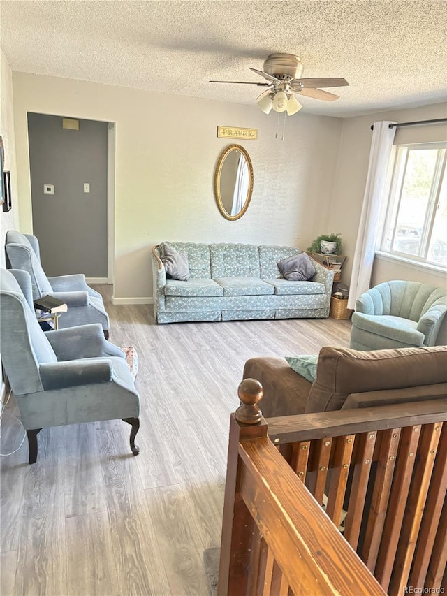 428 Prospect Ave, La Junta, CO 81050 - living room featuring baseboards, a ceiling fan, a textured ceiling, and wood finished floors