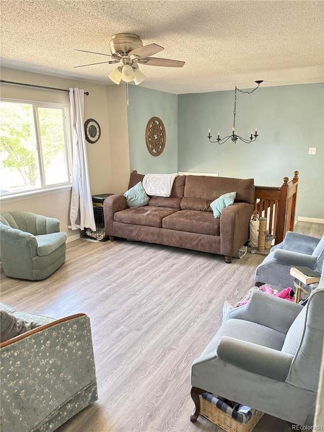 428 Prospect Ave, La Junta, CO 81050 - living room with a textured ceiling, ceiling fan with notable chandelier, and wood finished floors