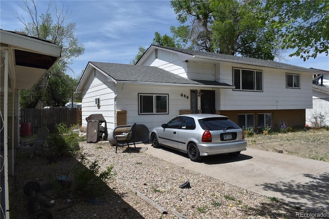 428 Prospect Ave, La Junta, CO 81050 - view of front of home with fence, concrete driveway, and roof with shingles