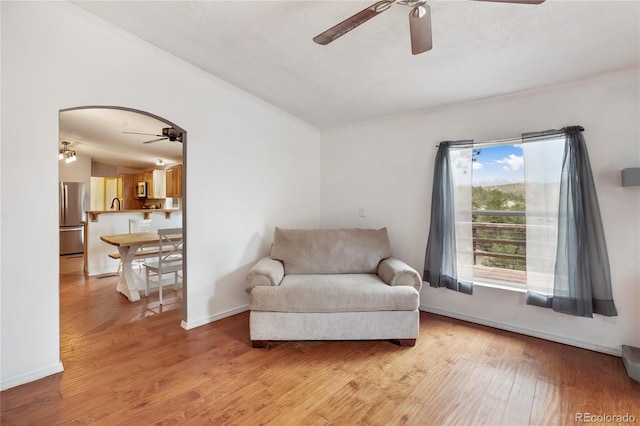 840 Obsidian Dr, Florissant, CO 80816 - living area featuring ceiling fan, ornamental molding, light wood-style floors, arched walkways, and baseboards