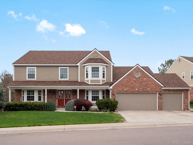 view of front of house with roof with shingles, an attached garage, brick siding, a front yard, and concrete driveway