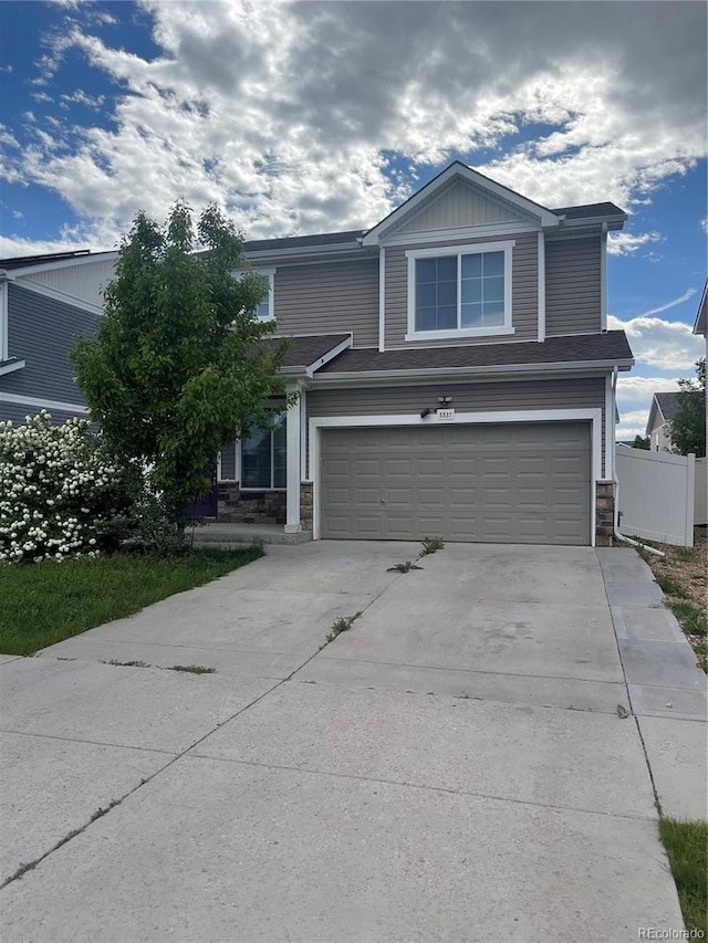 5537 Malta St, Denver, CO 80249 - view of front facade with stone siding, a garage, driveway, and fence