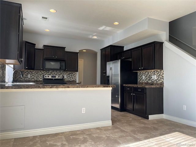 5537 Malta St, Denver, CO 80249 - kitchen with appliances with stainless steel finishes, a peninsula, arched walkways, tasteful backsplash, and a sink