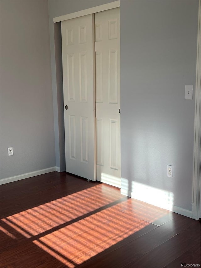 5537 Malta St, Denver, CO 80249 - unfurnished bedroom with dark wood-style floors, baseboards, and a closet
