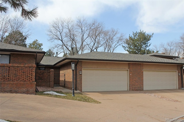 view of front facade featuring brick siding, driveway, and a garage