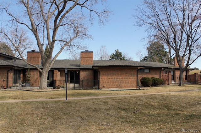 ranch-style home featuring a front yard, brick siding, a chimney, and fence