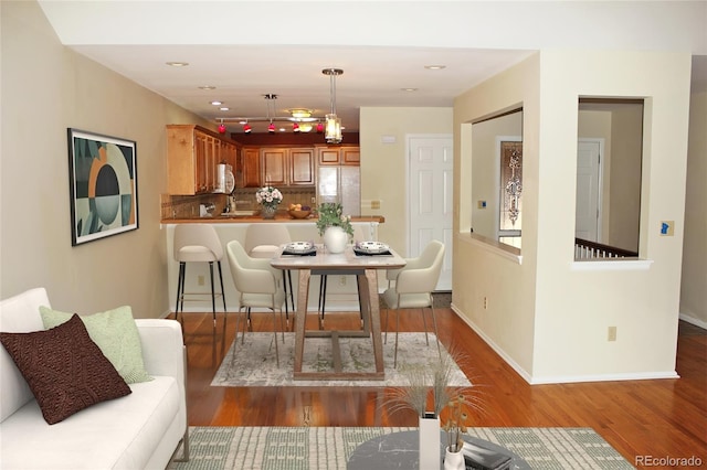 dining space with recessed lighting, baseboards, and wood finished floors
