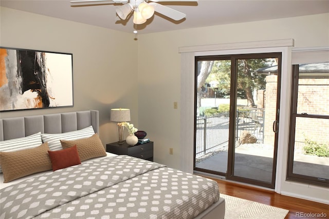 bedroom with access to outside, wood finished floors, and a ceiling fan