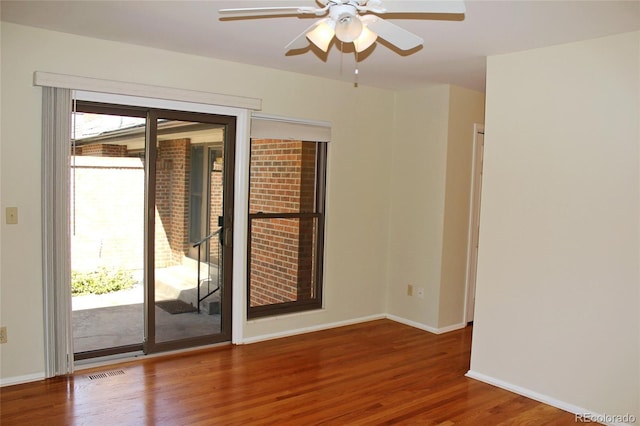 unfurnished room with baseboards, a ceiling fan, visible vents, and wood finished floors
