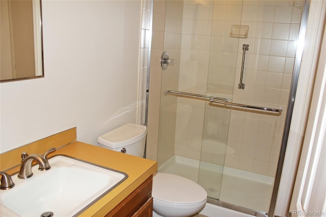 bathroom with vanity, toilet, and a stall shower