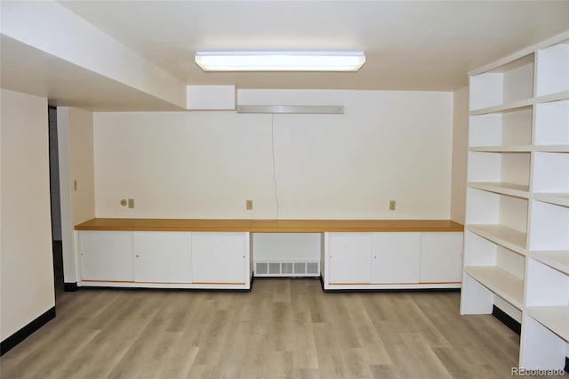 below grade area featuring light wood finished floors and visible vents