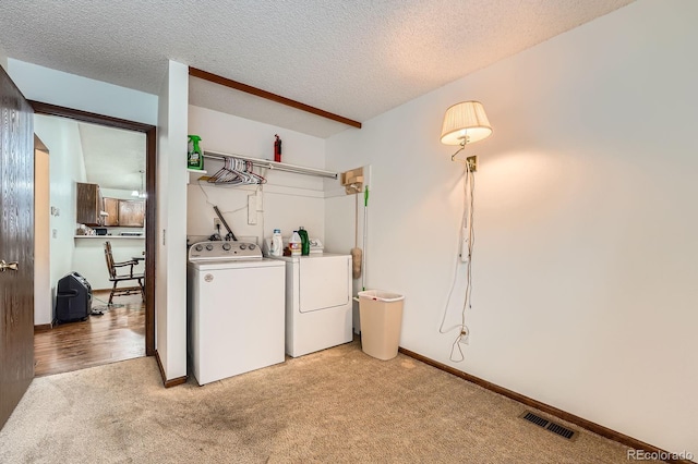 4162 S Dunkirk Way, Aurora, CO 80013 - laundry room featuring separate washer and dryer, light colored carpet, and a textured ceiling