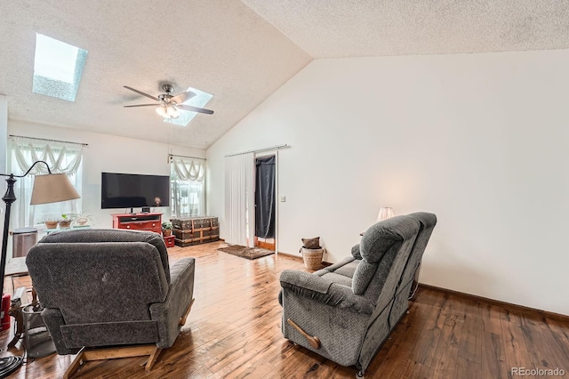4162 S Dunkirk Way, Aurora, CO 80013 - living area featuring a skylight, lofted ceiling, a textured ceiling, ceiling fan, and hardwood / wood-style floors