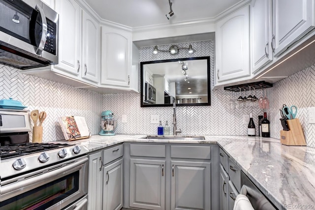 kitchen featuring a sink, appliances with stainless steel finishes, gray cabinetry, and white cabinetry