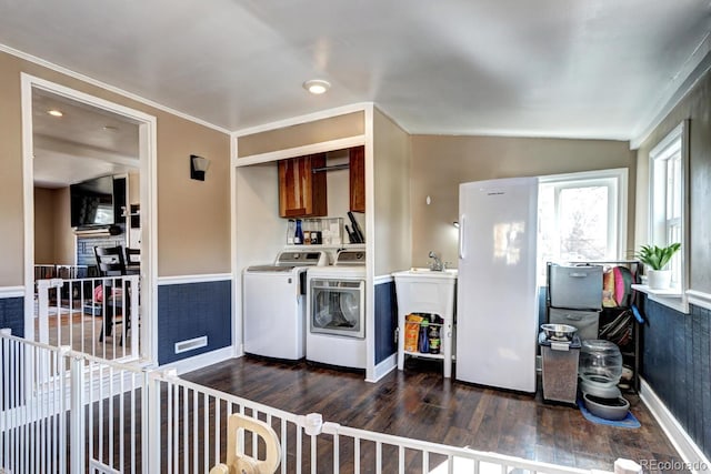 laundry area with dark wood finished floors, cabinet space, baseboards, and separate washer and dryer