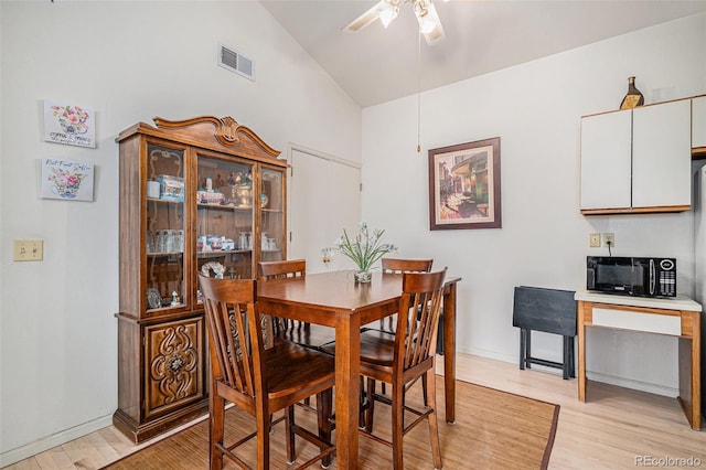 dining area with vaulted ceiling, ceiling fan, and light hardwood / wood-style floors