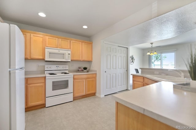 kitchen with sink, white appliances, light brown cabinets, and hanging light fixtures