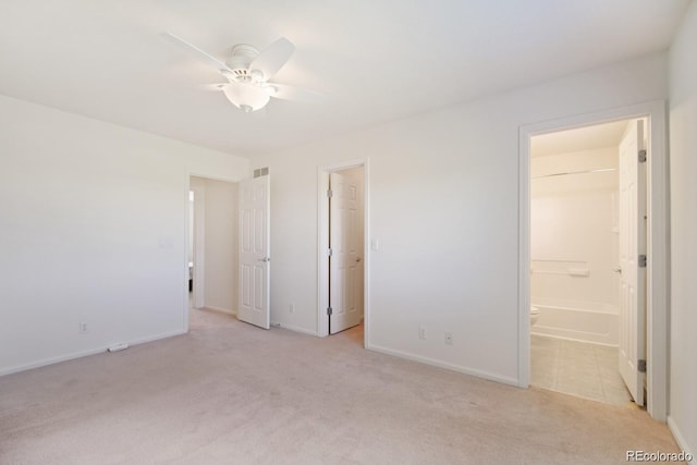 unfurnished bedroom with light carpet, ceiling fan, ensuite bathroom, a walk in closet, and a closet