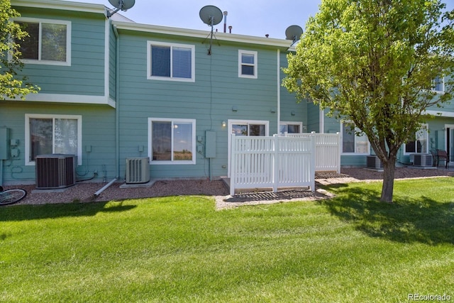 back of house featuring cooling unit and a lawn