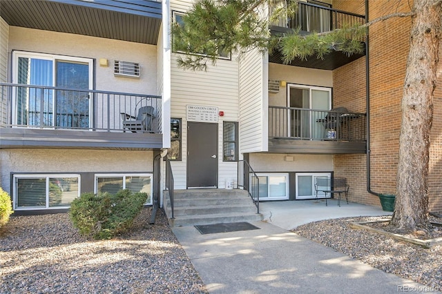 doorway to property with a balcony and stucco siding