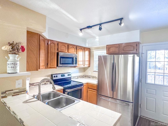 15475 E Louisiana Ave, Aurora, CO 80017 - kitchen with appliances with stainless steel finishes, tile countertops, a sink, and rail lighting