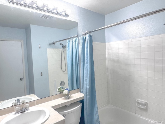 15475 E Louisiana Ave, Aurora, CO 80017 - bathroom with shower / bath combo with shower curtain, toilet, a textured wall, and vanity