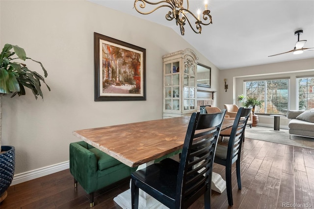 dining area featuring dark wood-type flooring, ceiling fan with notable chandelier, and vaulted ceiling