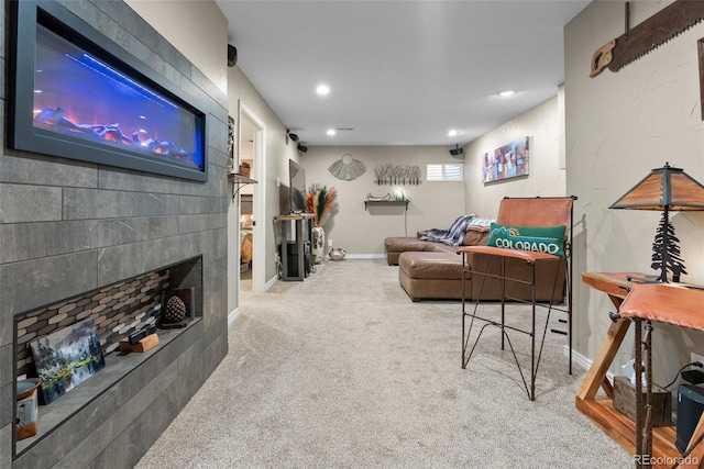 living room with a tile fireplace and carpet