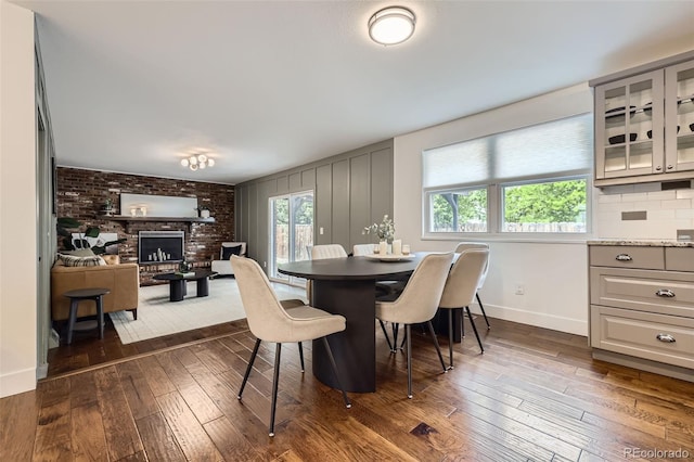 7746 S Gray St, Littleton, CO 80128 - dining room with dark wood-type flooring, a fireplace, and baseboards