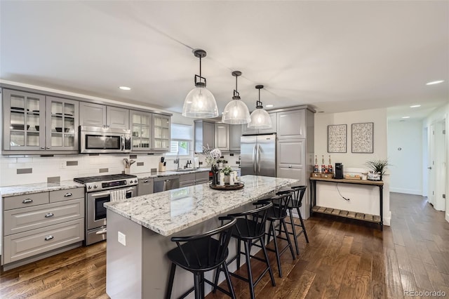 7746 S Gray St, Littleton, CO 80128 - kitchen featuring gray cabinets, appliances with stainless steel finishes, a sink, a breakfast bar, and recessed lighting