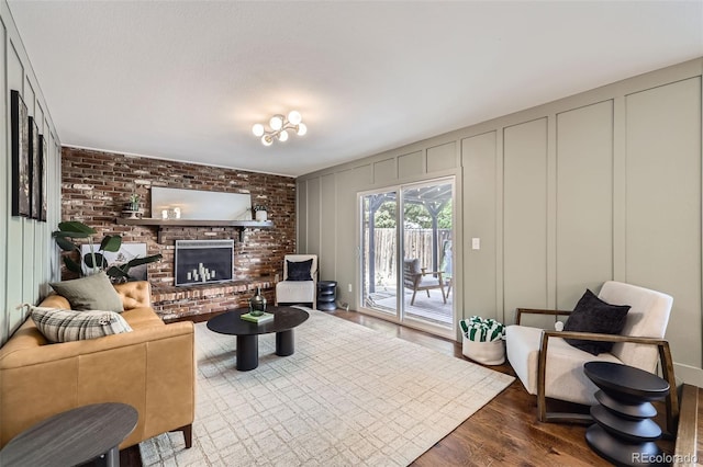 7746 S Gray St, Littleton, CO 80128 - living area featuring a decorative wall, wood finished floors, and a brick fireplace