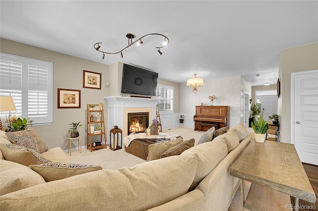 living area with a glass covered fireplace, carpet, and a chandelier