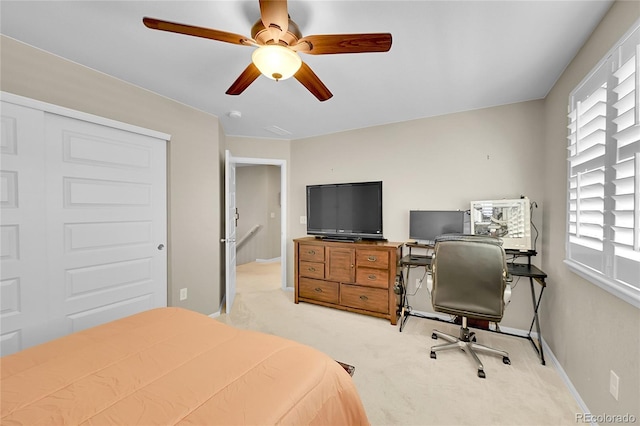 bedroom with baseboards, ceiling fan, and light carpet