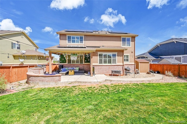 back of house with a storage shed, a patio, a yard, and an outdoor hangout area