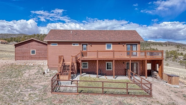 7103 Ranch Rd, Hartsel, CO 80449 - rear view of property featuring a deck with mountain view, stairs, a fenced backyard, a patio area, and a shingled roof