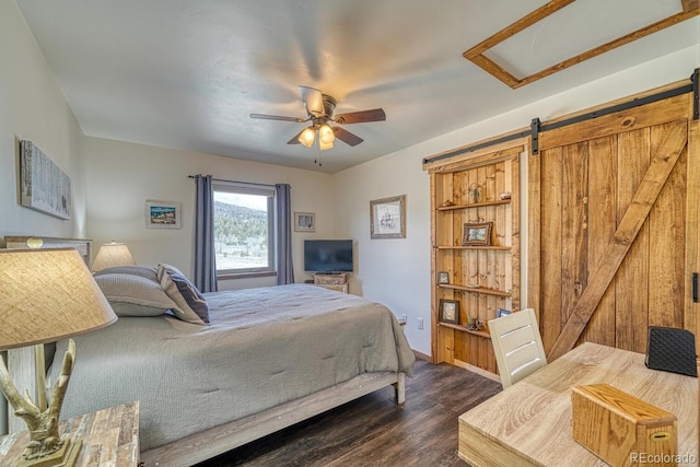 7103 Ranch Rd, Hartsel, CO 80449 - bedroom with dark wood-style floors, a barn door, a ceiling fan, and baseboards