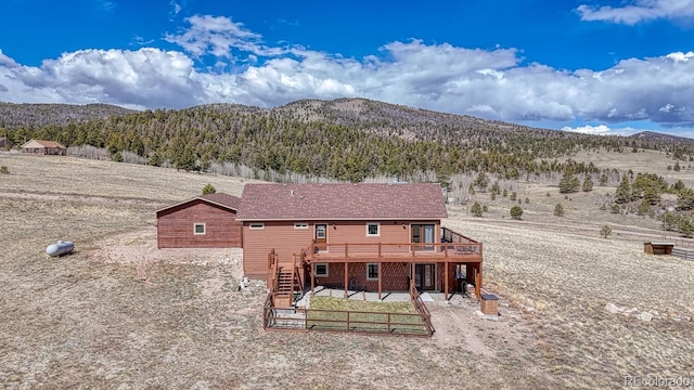 7103 Ranch Rd, Hartsel, CO 80449 - rear view of property featuring a deck with mountain view, stairway, and a view of trees
