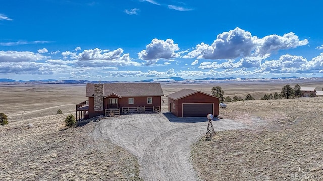7103 Ranch Rd, Hartsel, CO 80449 - view of front of house with an outbuilding, dirt driveway, an attached garage, a rural view, and a mountain view
