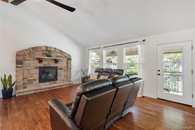 living area featuring ceiling fan, hardwood / wood-style flooring, a fireplace, and high vaulted ceiling