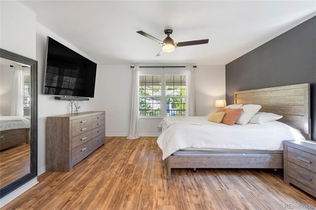bedroom with wood finished floors, baseboards, and a ceiling fan