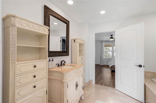 ensuite bathroom with vanity, recessed lighting, baseboards, and ceiling fan