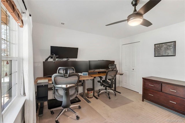 office area with a ceiling fan and light carpet