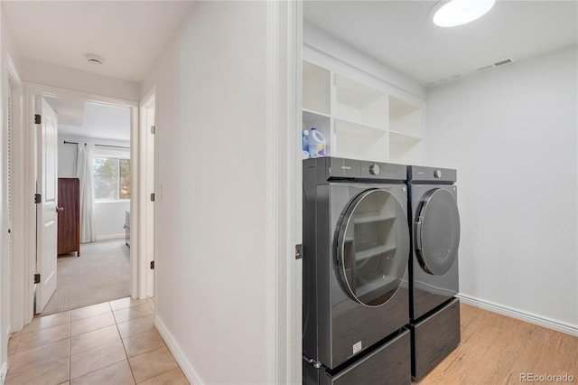 laundry area with washing machine and clothes dryer and baseboards