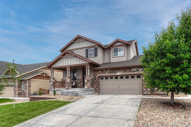 22583 E Union Cir, Aurora, CO 80015 - view of front of property with covered porch, driveway, a garage, board and batten siding, and stone siding