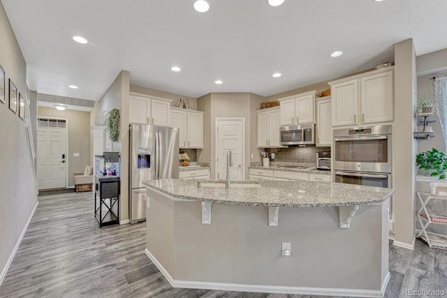 22583 E Union Cir, Aurora, CO 80015 - kitchen featuring appliances with stainless steel finishes, light wood-style floors, white cabinetry, light stone countertops, and recessed lighting