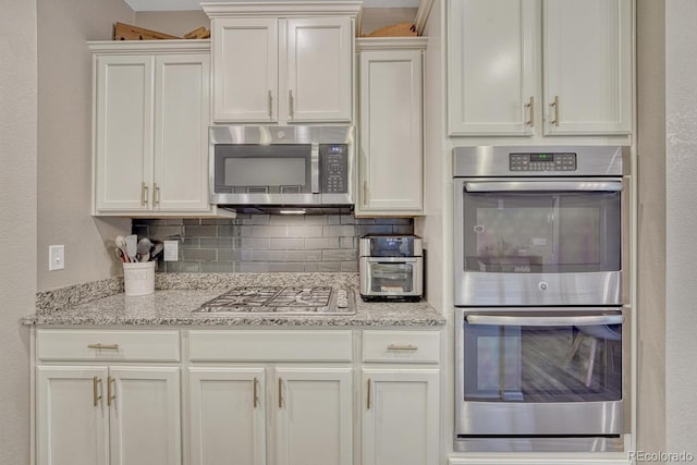 22583 E Union Cir, Aurora, CO 80015 - kitchen with stainless steel appliances, decorative backsplash, white cabinets, and light stone countertops