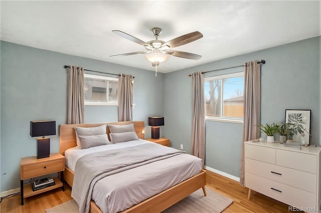 bedroom featuring light wood finished floors, ceiling fan, and baseboards