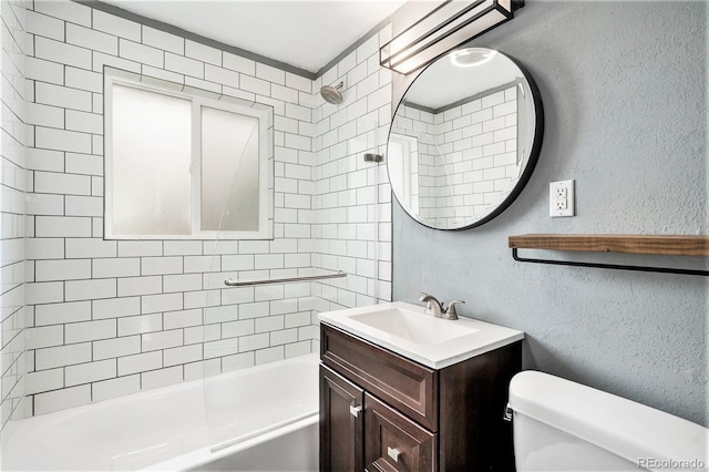 bathroom with vanity, toilet, a textured wall, and shower / washtub combination